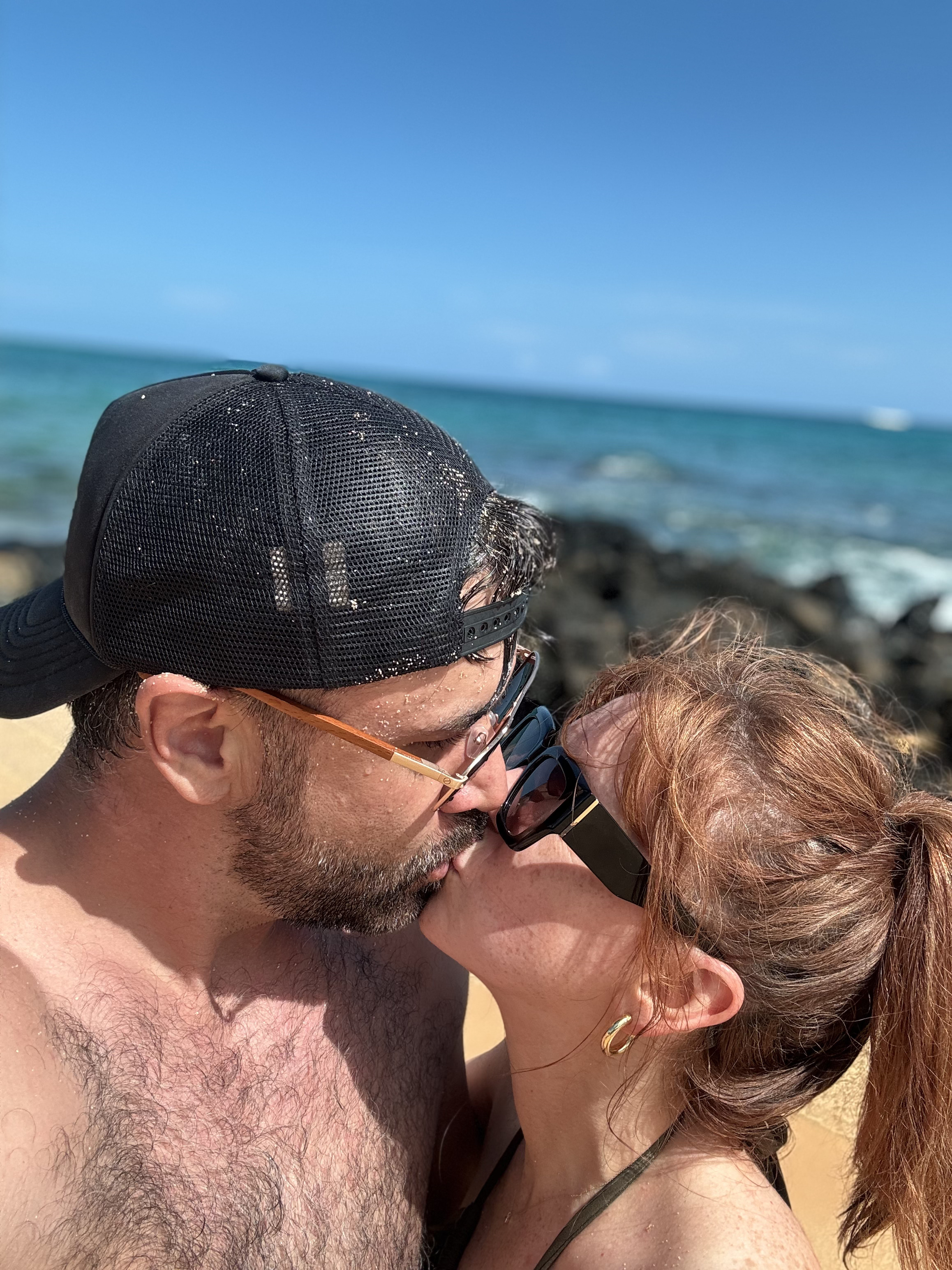 A kiss on the beach over turquoise water
